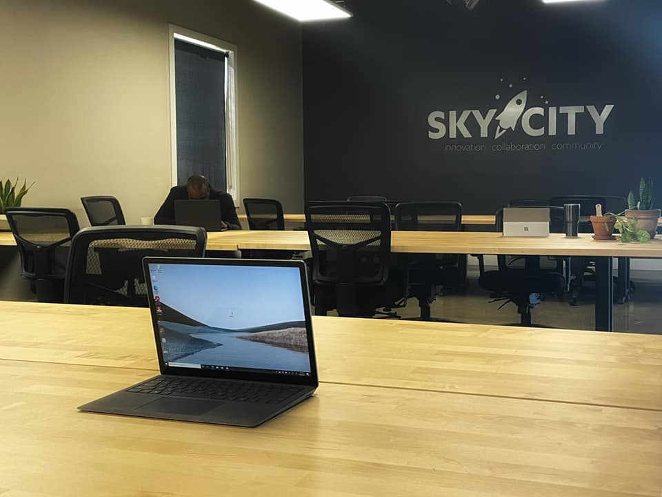 Image of a laptop on one of Sky City's conference tables with the Sky City logo on the back wall